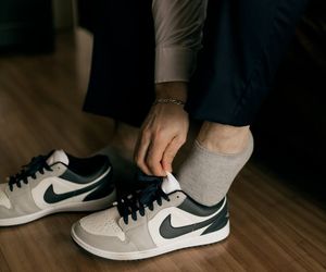 Close-up of athletic shoes on a dark floor, ready for action.