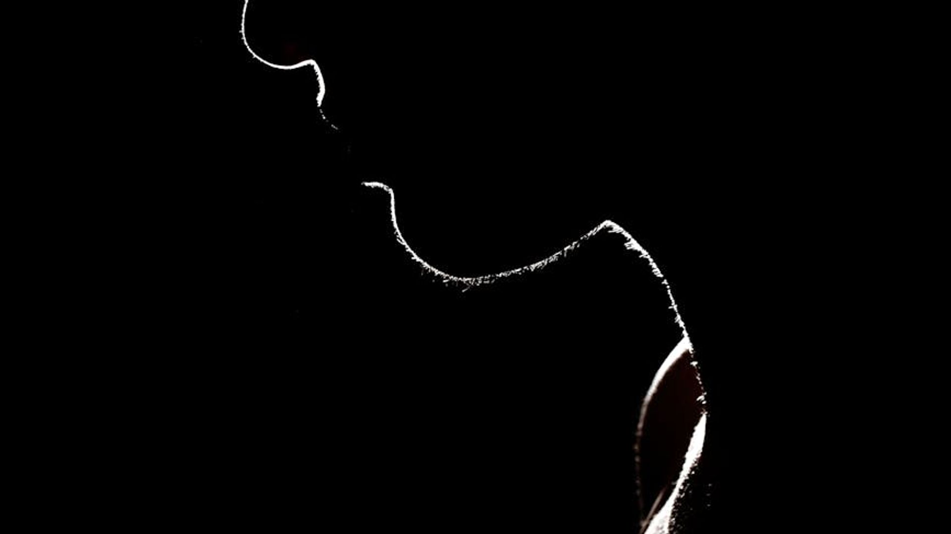 Silhouette of a person in a dynamic cardio pose against a dark background.